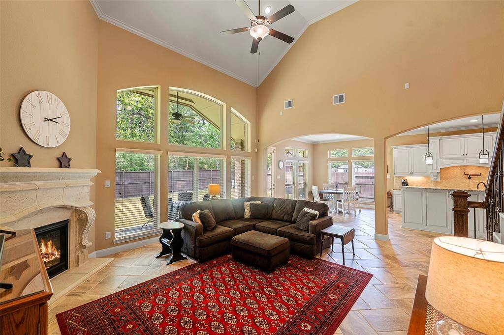 Spacious family room with 19-foot ceiling and gas fireplace enhanced by the wrought iron staircase.
