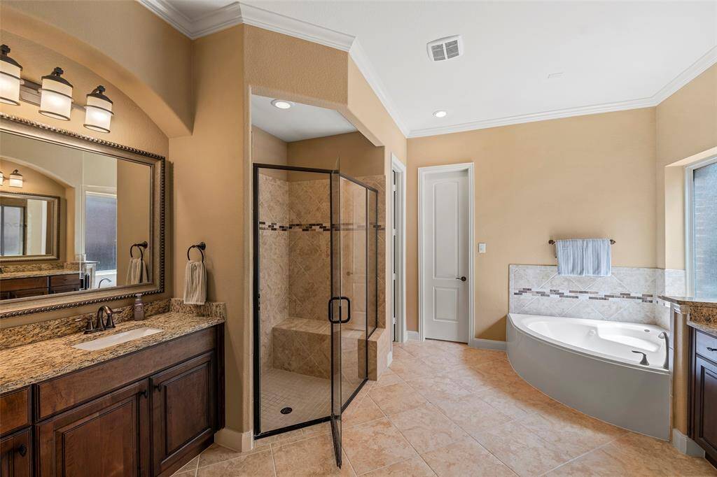 Ensuite primary bath has granite countertops, walk-in shower with bench, and dual undermount sinks.