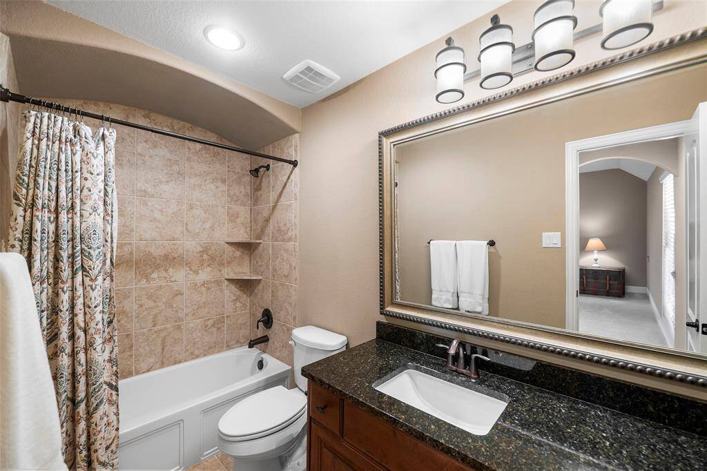 Ensuite bathroom has granite counter top and shower/tub combo.