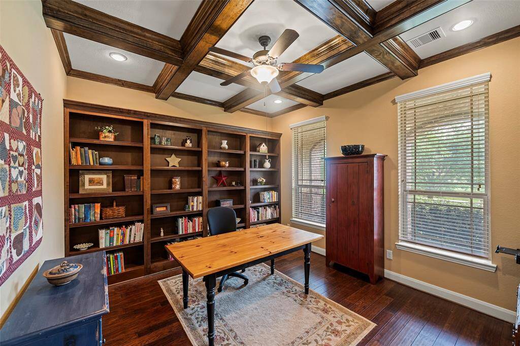 Stunning home office with wood beam ceiling, built-ins and wood floor.
