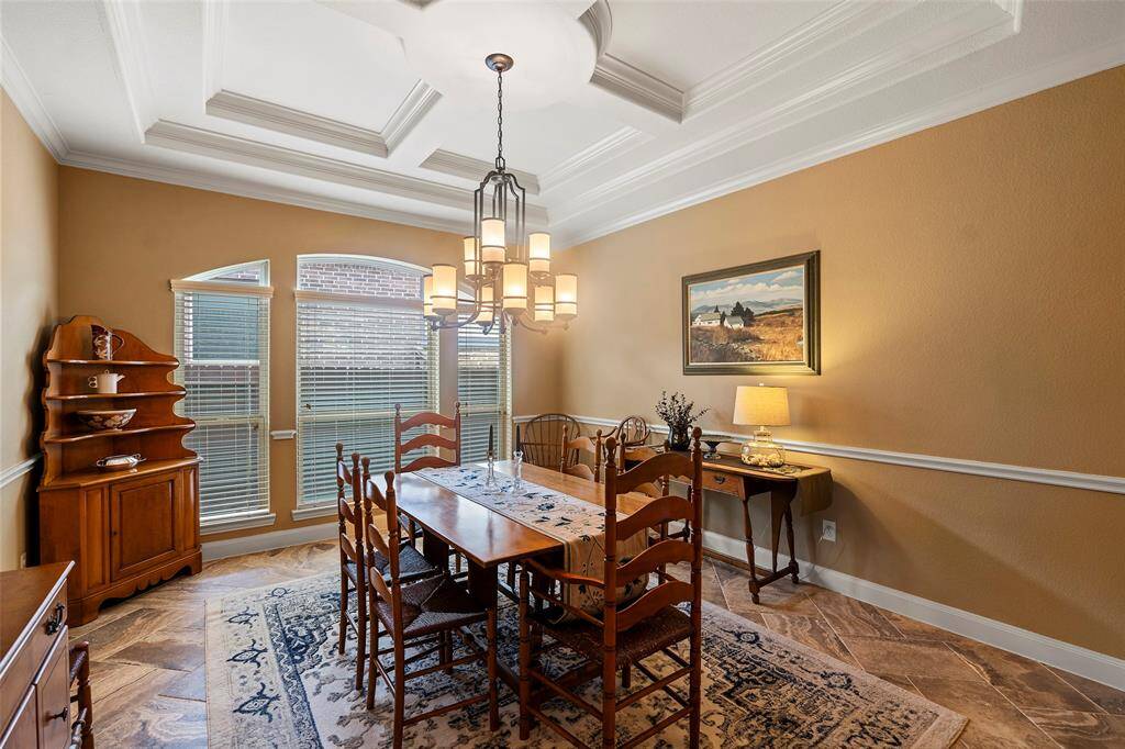 Beautiful formal dining with coffered ceiling and chair rail.