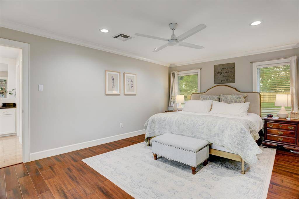 The Primary Bedroom features double doors leading to the oversized Back Patio, bamboo floors crown molding, LED recessed lights and large windows with custom window coverings.