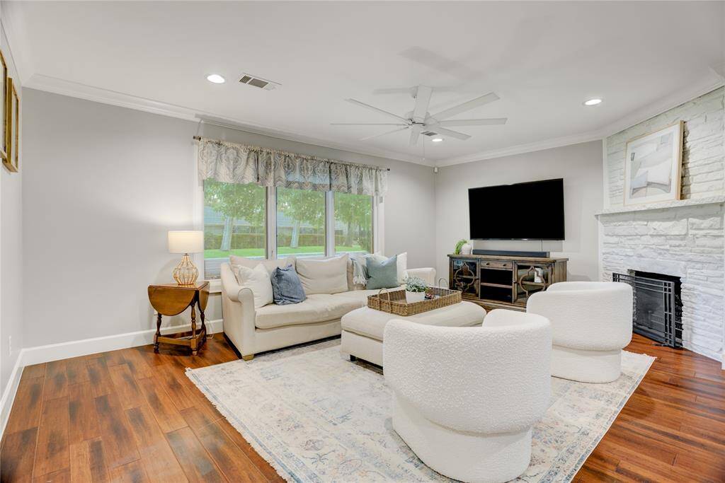 The Family Room features a mock fireplace with stone surround, large windows providing wonderful natural light and overlooking the front yard, bamboo floors, recessed LED lights and crown molding.
