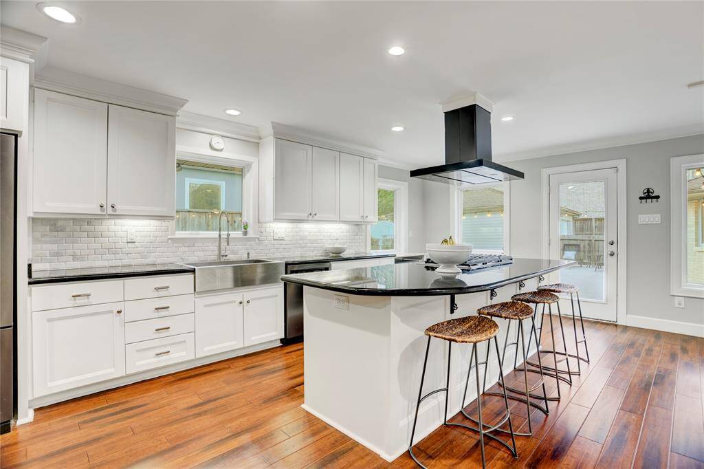 The updated Kitchen is beautifully on-trend and features timeless black granite countertops, marble tile backsplash, tons of custom white cabinetry with polished nickel hardware and stainless-steel KitchenAid appliances: gas cooktop with 5 burners, 2 ovens, refrigerator + freezer and dishwasher.