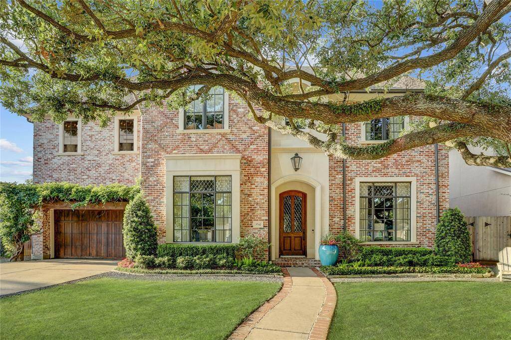 Custom built timeless brick and stone home with Tudor style leaded glass diamond windows and beautiful oak tree perfectly framed for amazing curb appeal - welcome!
