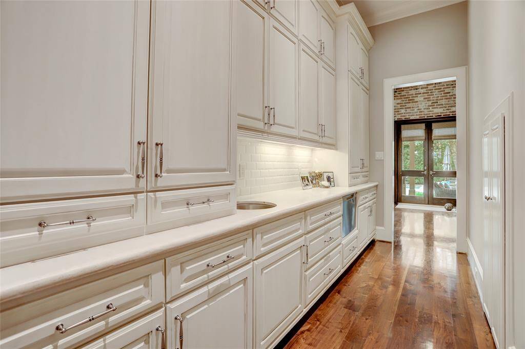 Butler pantry with travertine counters leading to the kitchen and family room.
