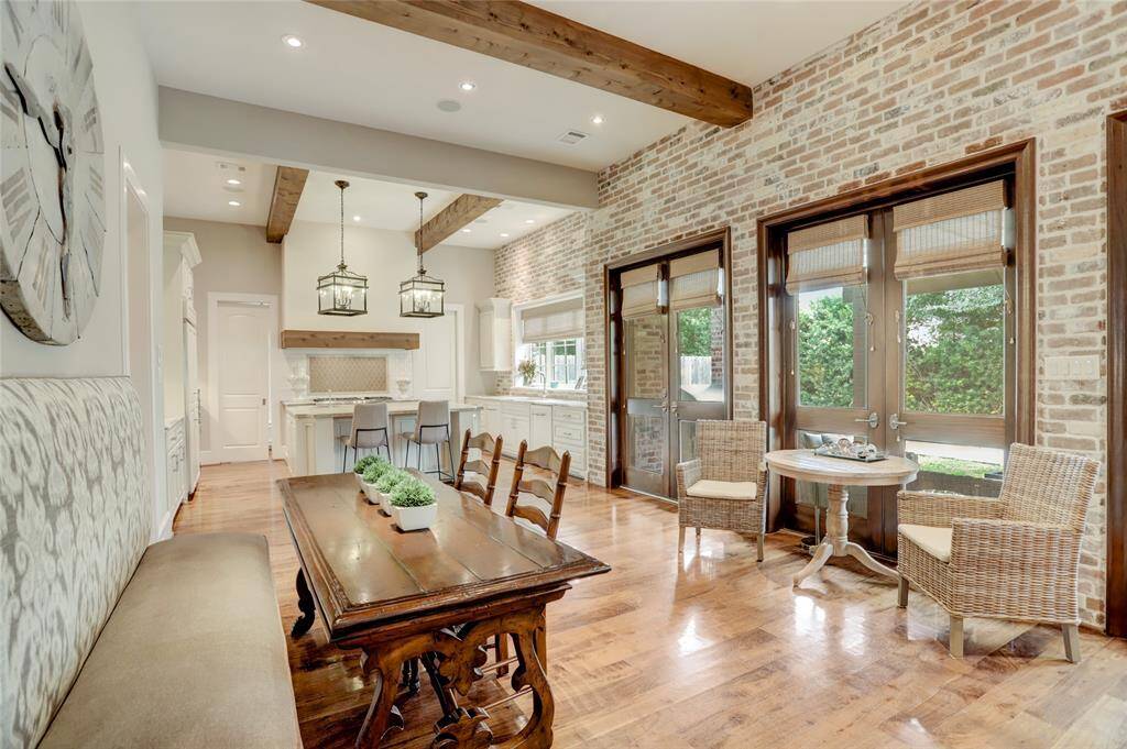 Another view of the breakfast room looking o the kitchen with beautiful brick accented wall and wood beams