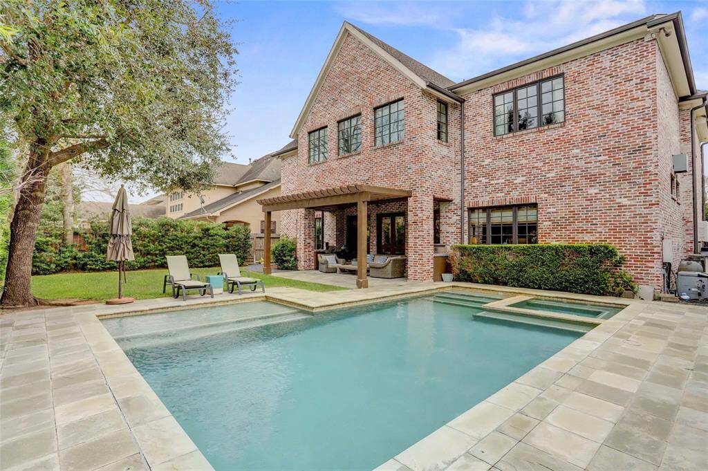 Lush landscaping, sparking pool and pergola ready to entertain outdoors.