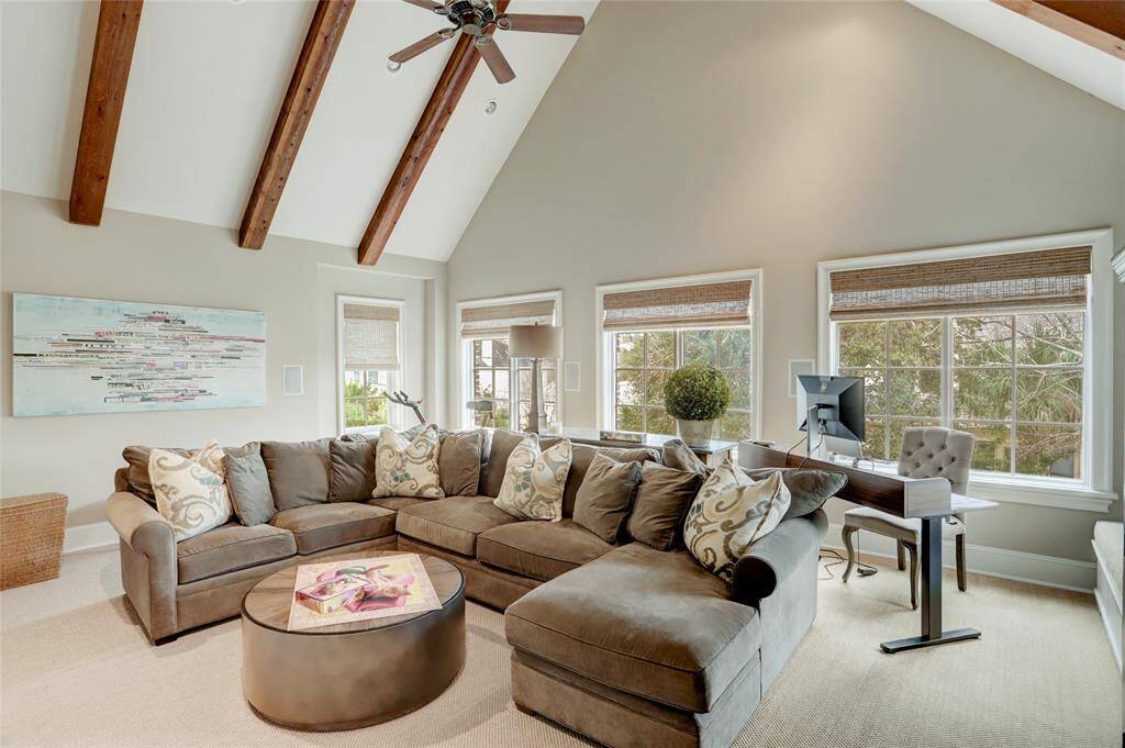 Spacious gaemroom upstairs with vaulted wood beam ceilings and windows overlooking the backyard
