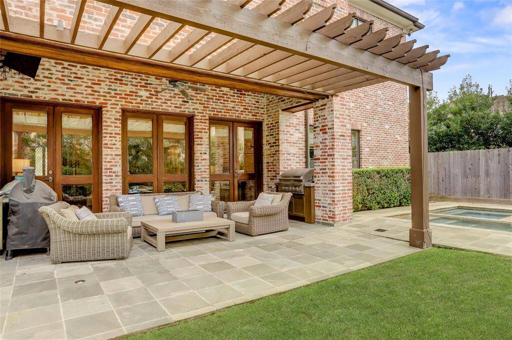 Another view of the outdoor living spaces opening to the expansive yard with pool.