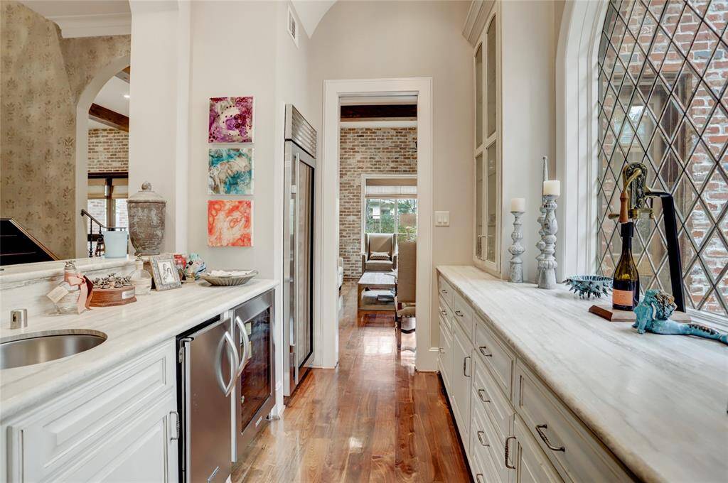 Perfect for entertaining, this wet bar with marble countertops opens to the living spaces with refrigerator(s), sink, ample counter space and storage, beautiful diamond window overlooking the bistro porch.