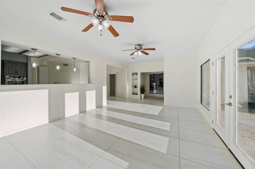 Spacious family room that doubles as a game room, featuring large windows that allow plenty of natural light to fill the space, creating a bright and welcoming atmosphere.