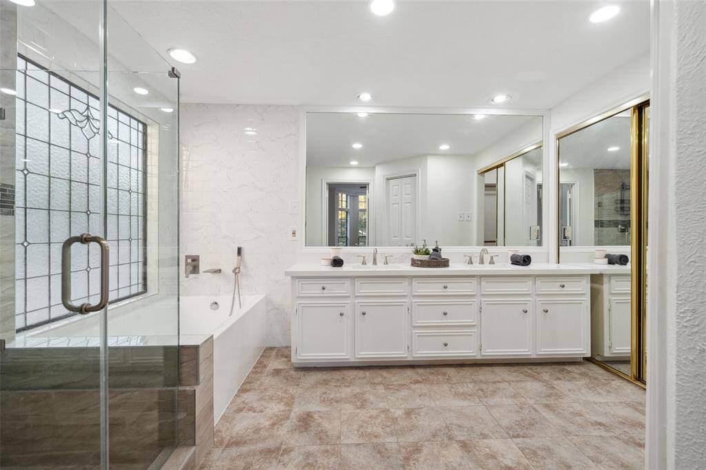 Spacious master bathroom featuring dual vanities, a soaking tub, and a separate shower.