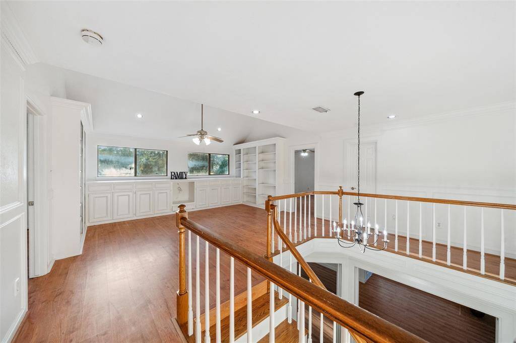 Spacious family room on the second floor, featuring built-in bookshelves and elegant woodwork on the walls.