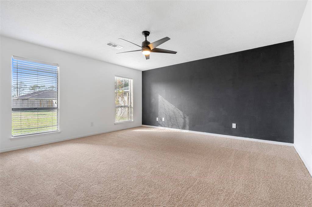 Primary bedroom with accent wall and New carpet