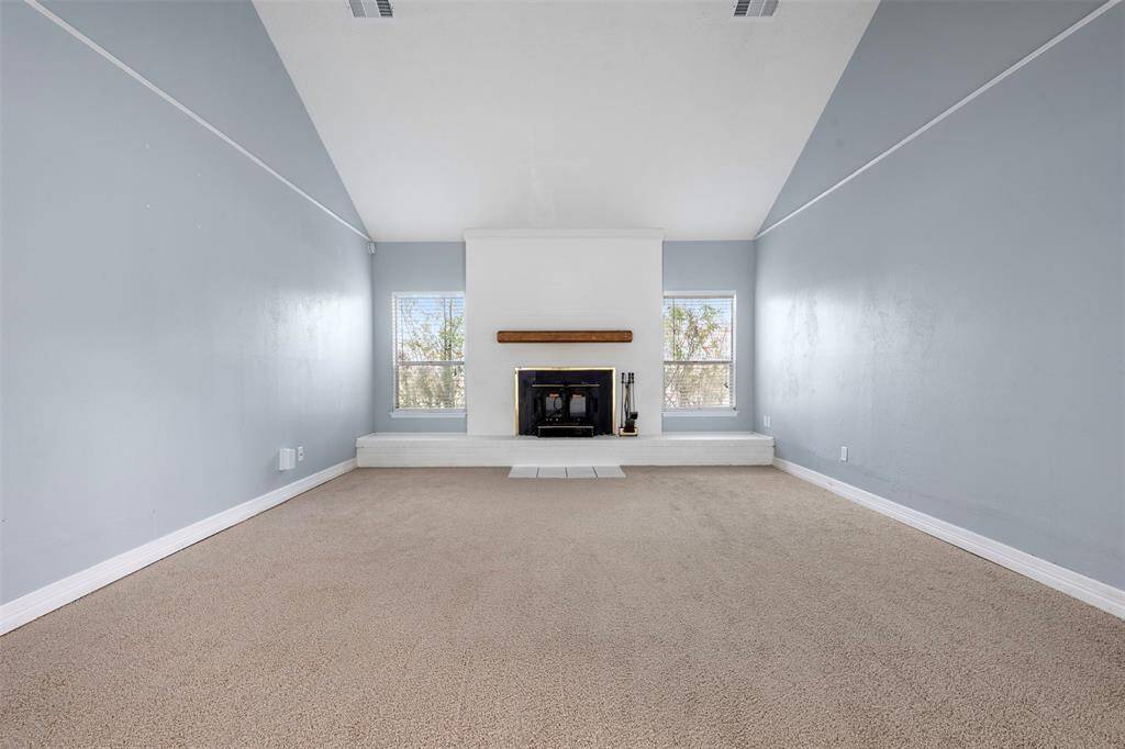 Spacious living space with cathedral ceiling and fireplace