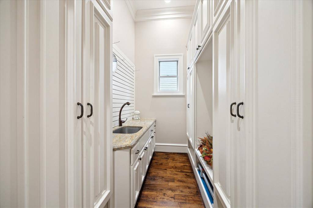 Wall-to-wall cabinetry outfits the mud room, complete with full sink.