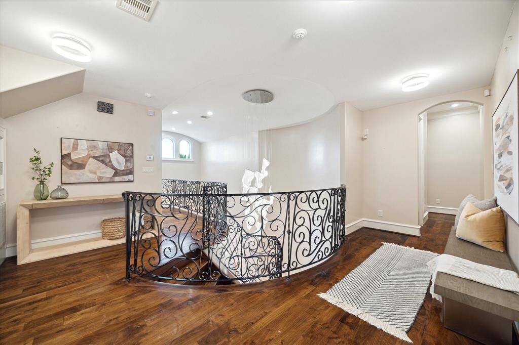 Walnut flooring and wrought-iron railings continue to the second-floor landing.