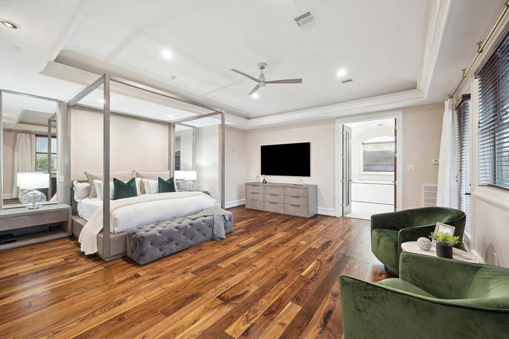 Spacious and light-filled, the primary bedroom includes room for a sitting area, recently refurbished walnut flooring, and a private balcony with new flooring.