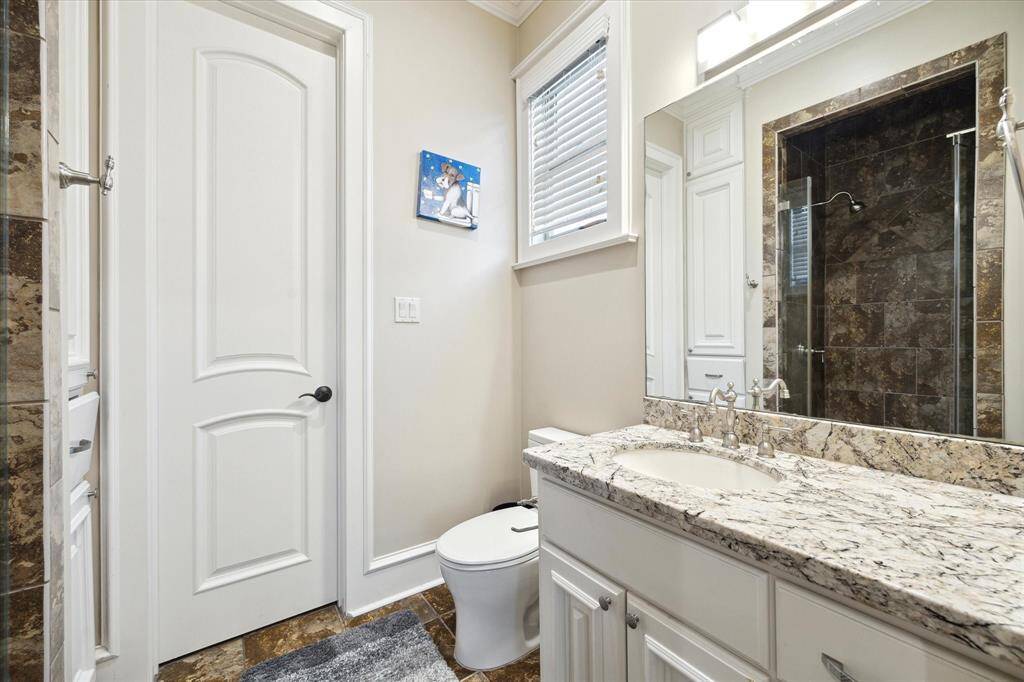 The final en-suite bathroom with granite counters, crown moulding, and step-in shower.