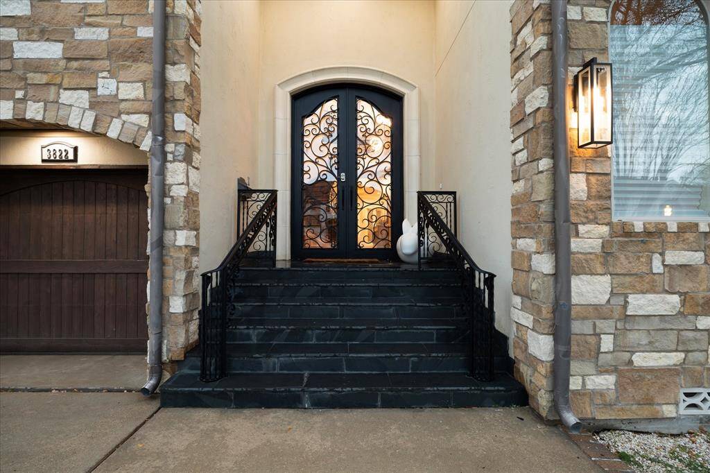Gracefully arched wrought-iron doors create a welcoming entrance that makes a statement.