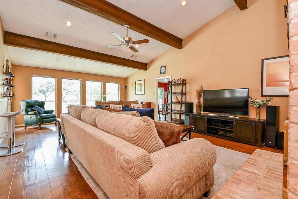 Spacious family room with accent beams and wood laminate flooring