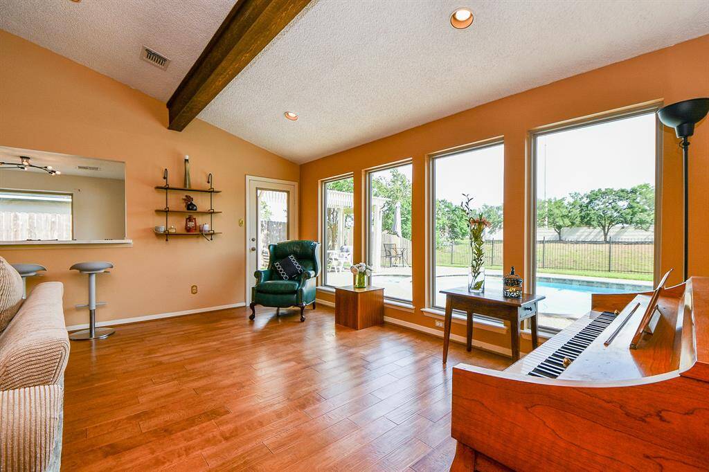 Big windows in the family room with a view of the pool and creek