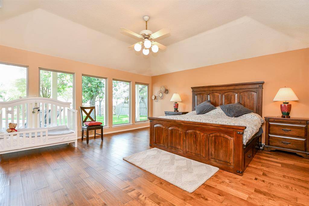 Extra larger primary bedroom with lots of windows overlooking the pool and creek