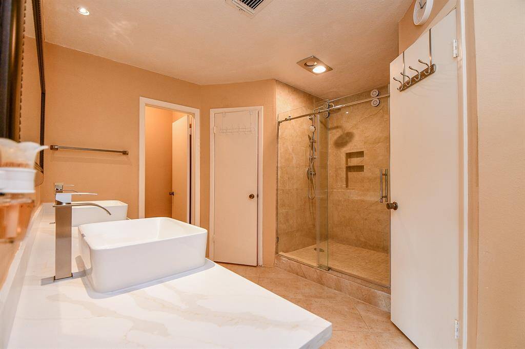 Primary bathroom with updated shower stall and tile backsplash