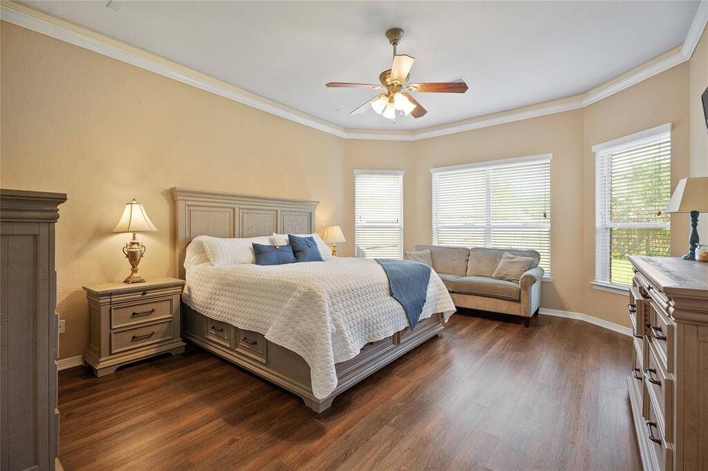 Primary Bedroom with crown molding and TV mount