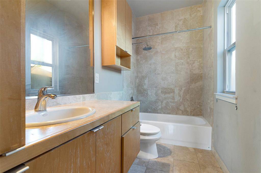 En-Suite Bath for Secondary Bedroom(approx. 10x5) featuring travertine tile,tub/shower combo, maple cabinetry.