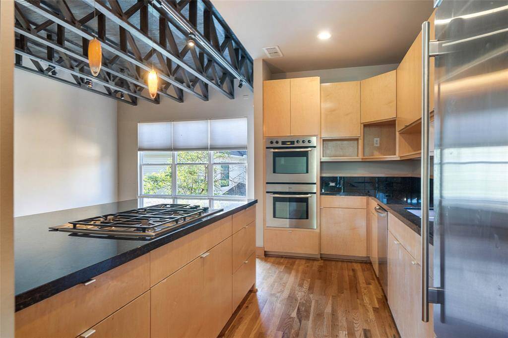 Modern kitchen (approx. 13x10)features maple cabinetry, wood floors,Bosch stainless steel appliances, gascooktop w/downdraft vent, doubleovens, Sub Zero built-in refrigerator,views to the family room/den, andgranite counters