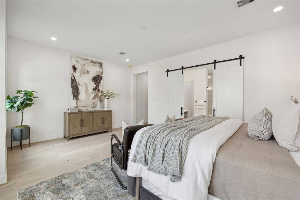Ensuite primary bath is framed with beautiful barn doors.