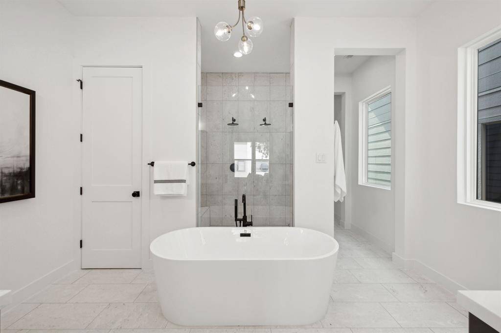 Spa inspired bathroom with large soaker tub and frameless shower with dual shower heads.