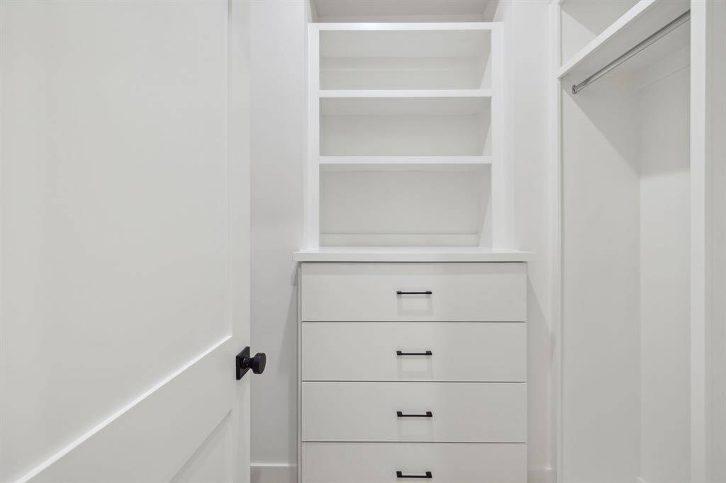 First primary closet featuring built in dresser.