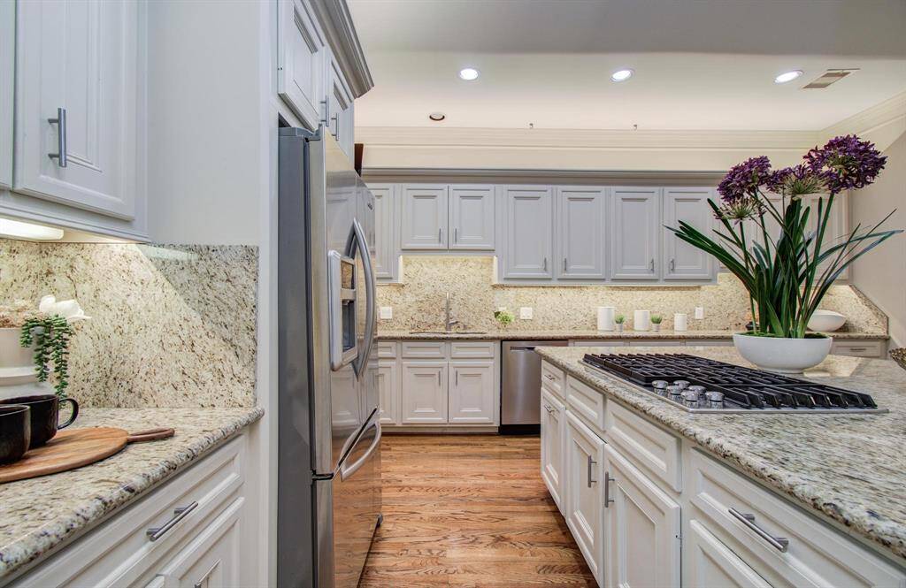 The kitchen boasts a KitchenAid cooktop with downdraft vent.