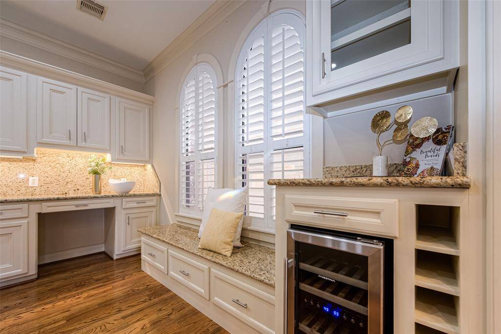 Cozy window seat with storage in the kitchen, a wine cooler, and ample counter space, creating a functional and inviting atmosphere.