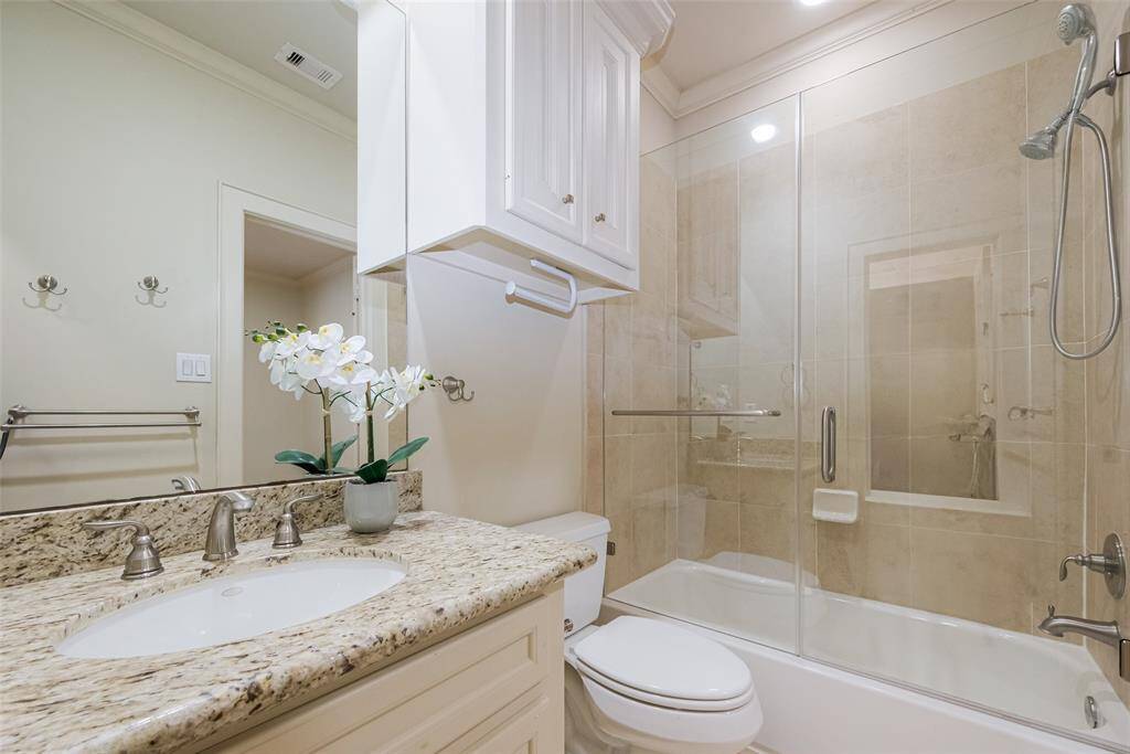 Ensuite in 3rd bedroomThe space includes a glass-enclosed bathtub with a shower, neutral tile walls, and ample lighting, creating a clean and sophisticated look.