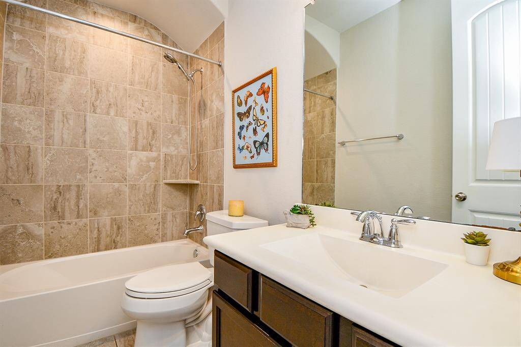 Full secondary bathroom with custom tile to ceiling.