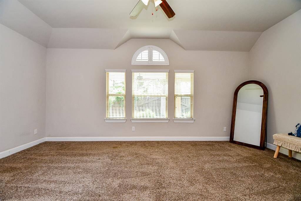 Another view of light and bright primary with large windows providing beautiful view of backyard.