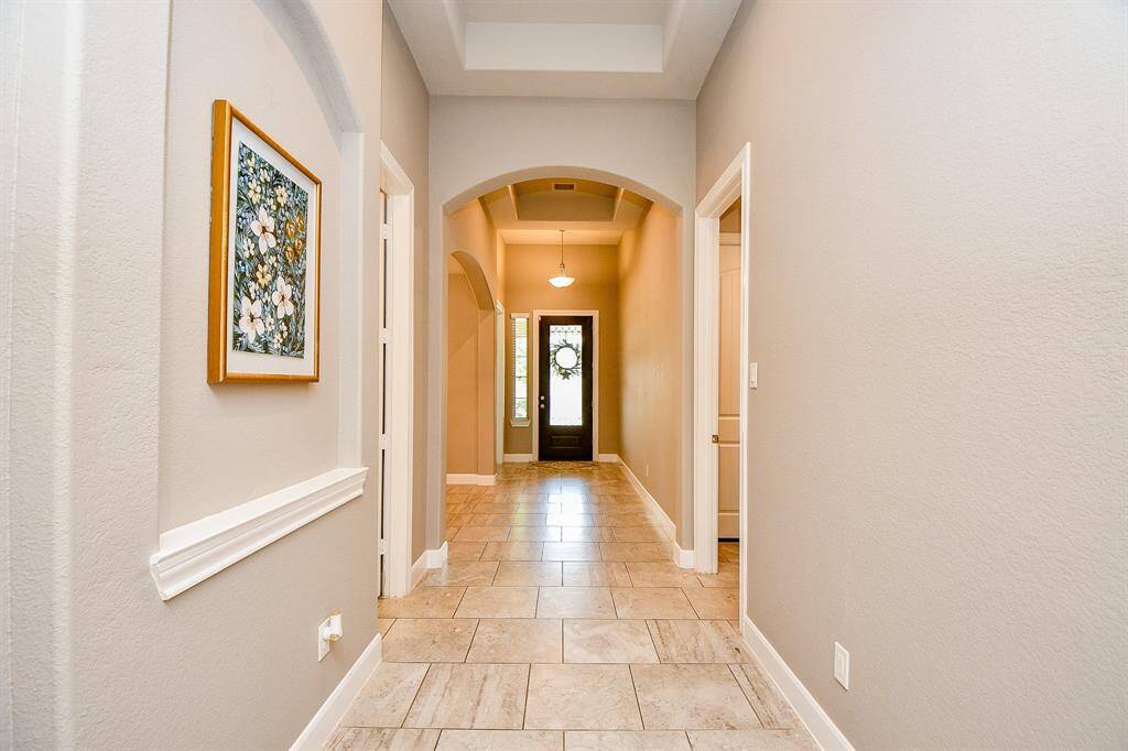 Beautiful long entry with high ceilings and art display.