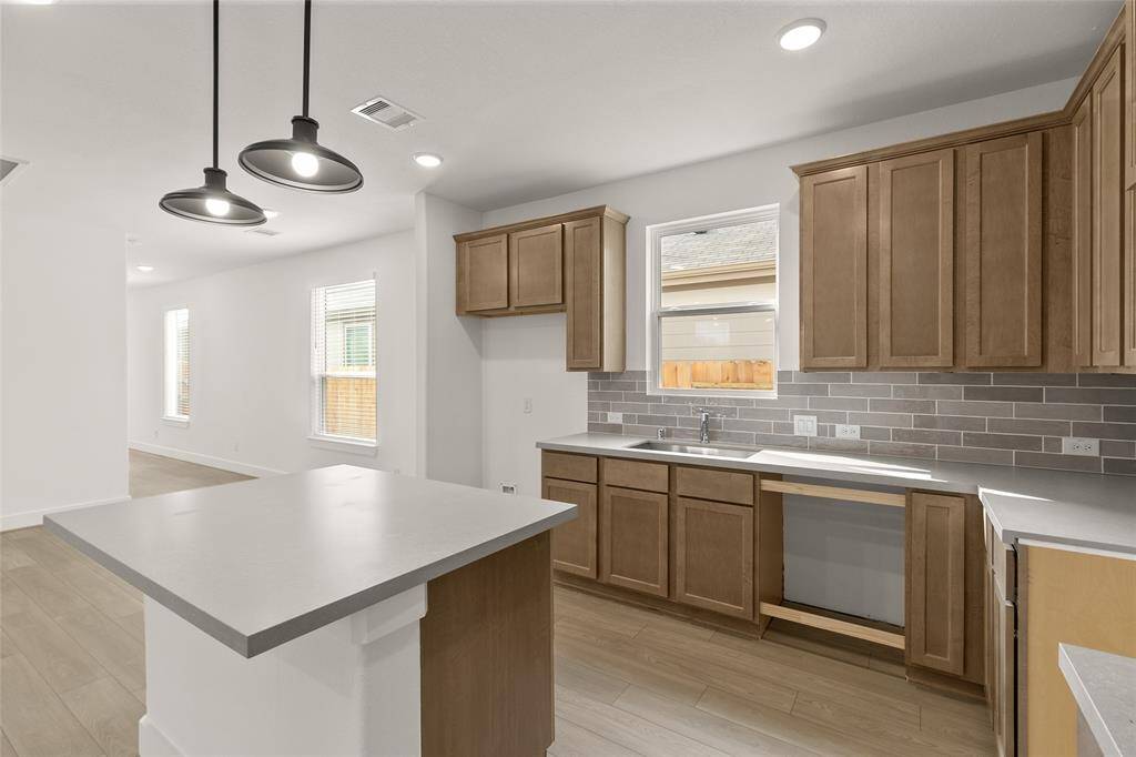 Natural light pours in through large windows, creating a bright and airy atmosphere that makes cooking feel less like a chore and more like a delightful experience. Microwave, Dishwasher, Stovetop range are included, just not pictured.