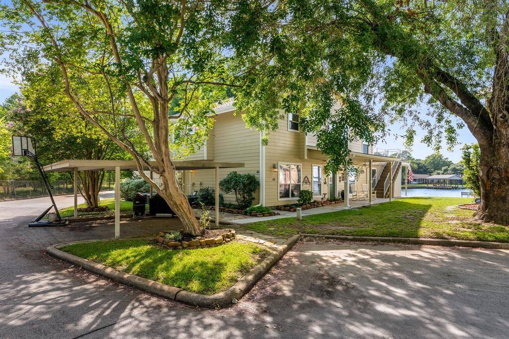 A canopy of mature trees surround the 2 car detached carport.