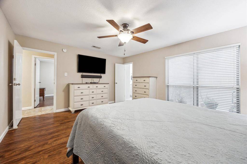 The large windows in the primary bedroom look out to the green room/ sitting area. Off to the back right, you'll find the fully remodeled primary bathroom suite.