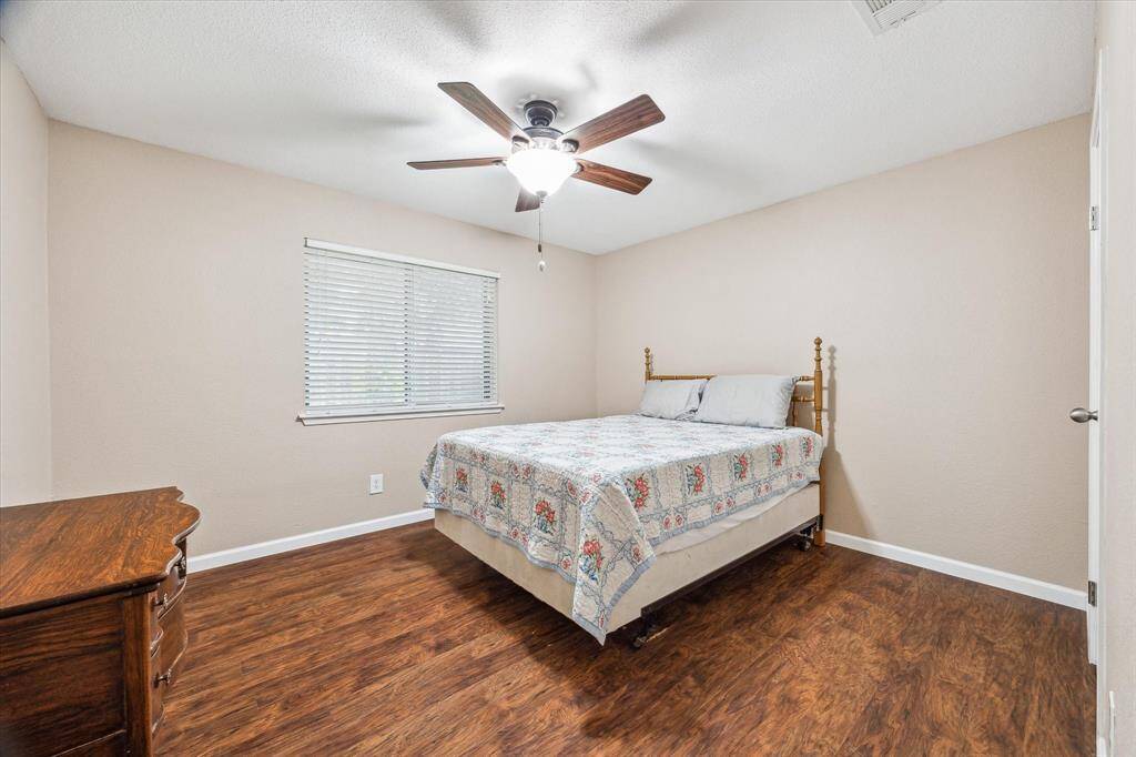 Another secondary bedroom with a ceiling fan and a large window.