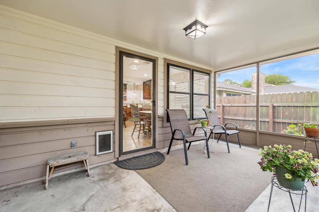 This photo showcases the screened-in porch/ sunroom. The space connects to the interior, providing a seamless indoor-outdoor flow.