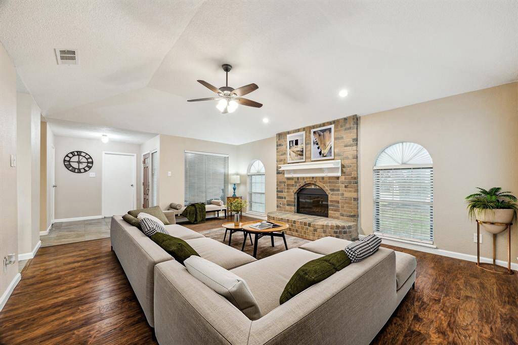 Freshly painted mantel above the fireplace and large windows create a welcoming atmosphere in this living room. Virtually Staged