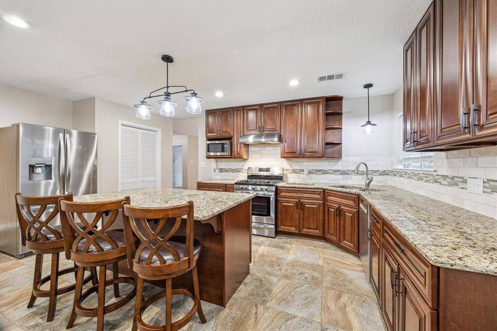 The kitchen provides plenty of countertop space for meal prep, cabinets, and a walk-in pantry off to the left.