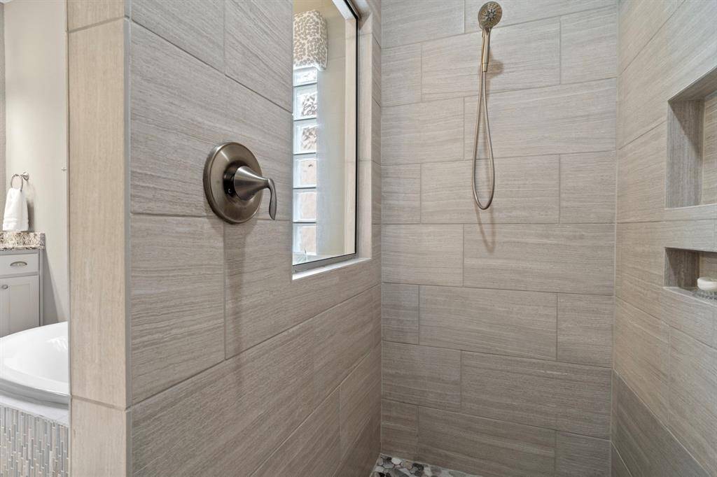 Shower features a bench, niche and tile to ceiling