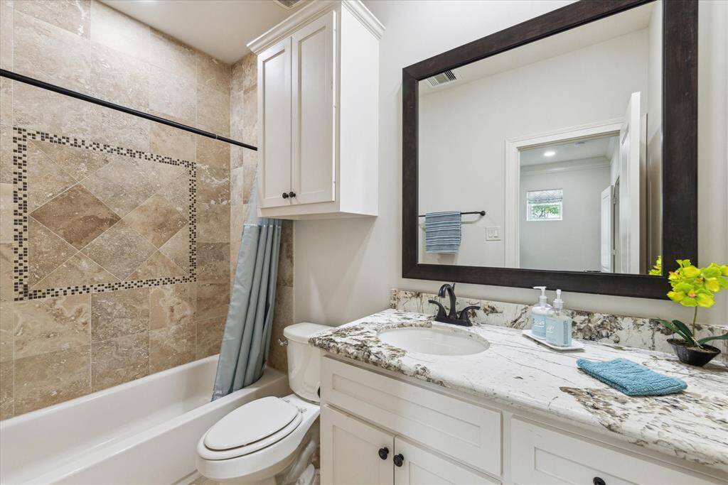 Secondary bath on the second floor with shower/ tub combo and granite countertop.